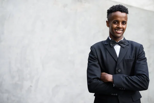 Ung vacker afrikansk affärsman som bär kostym mot betong — Stockfoto