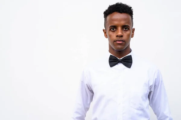 Jovem e bonito empresário africano vestindo gravata borboleta contra branco — Fotografia de Stock