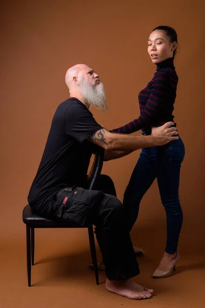 Зрілі бородатий лисий чоловік з жінкою молодих азіатської трансвеститів — стокове фото