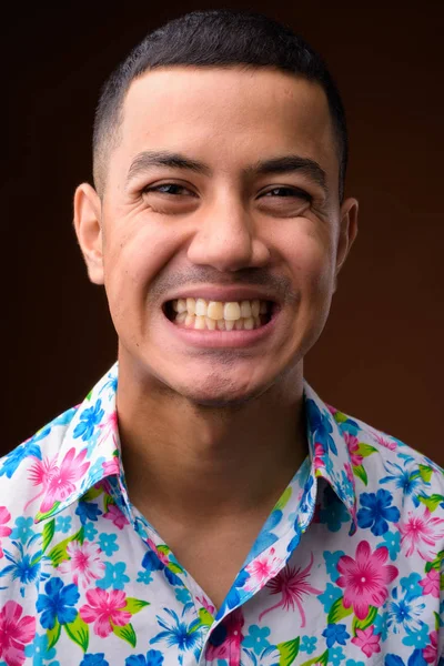Joven multi-étnico asiático turista hombre contra fondo marrón — Foto de Stock