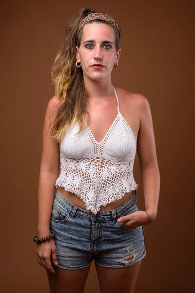 Jonge mooie Spaanse vrouw tegen bruine achtergrond — Stockfoto