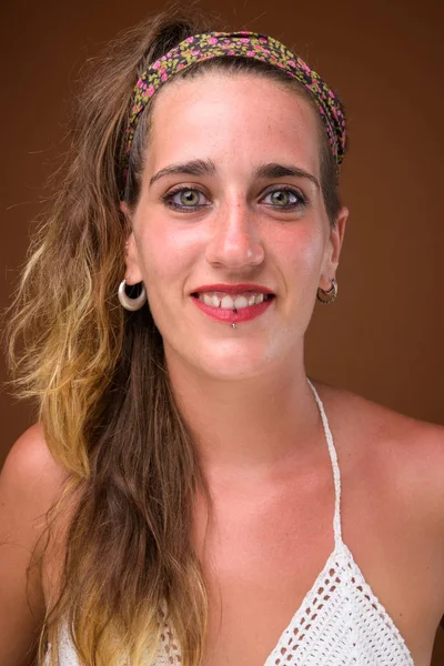 Junge schöne hispanische Frau vor braunem Hintergrund — Stockfoto