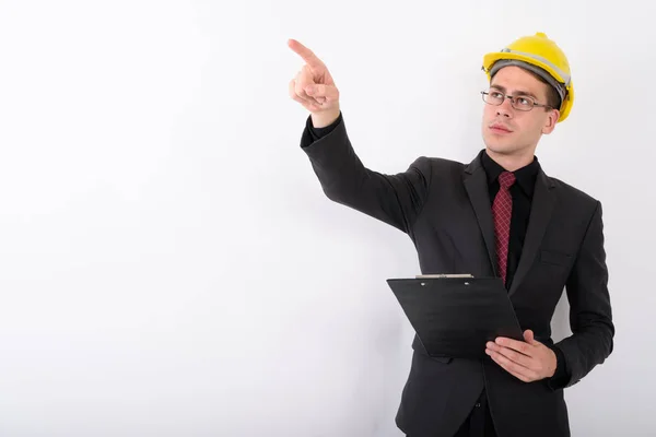 Joven hombre de negocios guapo vistiendo hardhat contra backgro blanco — Foto de Stock