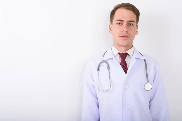 Junger schöner Mann Arzt vor weißem Hintergrund — Stockfoto