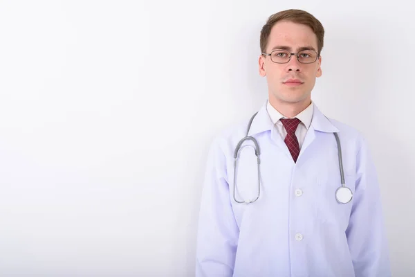 Jeune homme beau médecin portant des lunettes contre le dos blanc — Photo