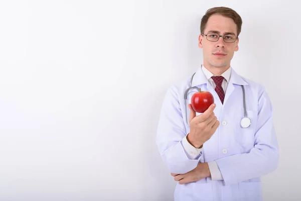 Jeune homme beau médecin portant des lunettes contre le dos blanc — Photo