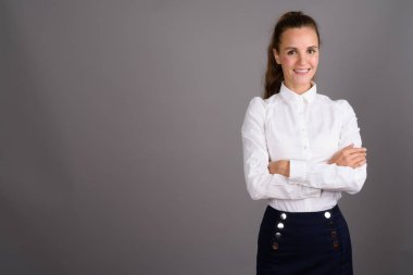 Genç güzel işkadını gri bir arka plana dayanır