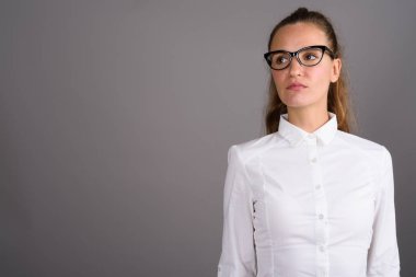 Genç güzel işkadını gri bir arka plana dayanır