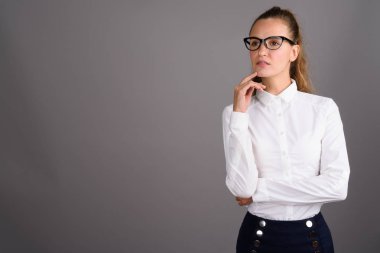 Genç güzel işkadını gri bir arka plana dayanır