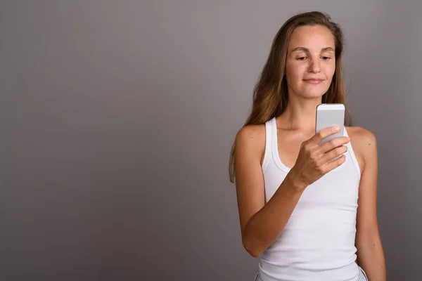 Joven hermosa mujer con el pelo largo y rubio usando el teléfono móvil — Foto de Stock