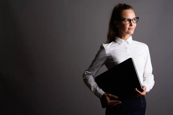 Young beautiful businesswoman against gray background — Stock Photo, Image