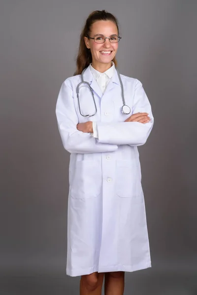 Jovem mulher bonita médico contra fundo cinza — Fotografia de Stock