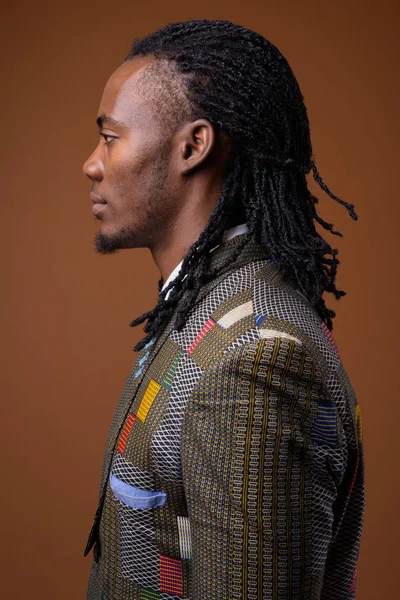 Genç yakışıklı Afrika işadamı kahverengi zemin karşı