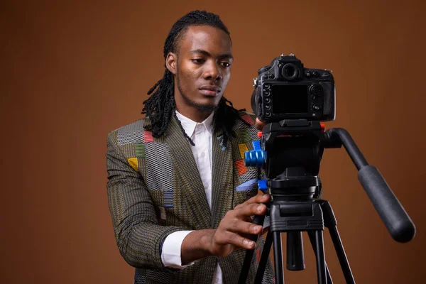 Mladý pohledný africký podnikatel proti hnědým pozadím — Stock fotografie