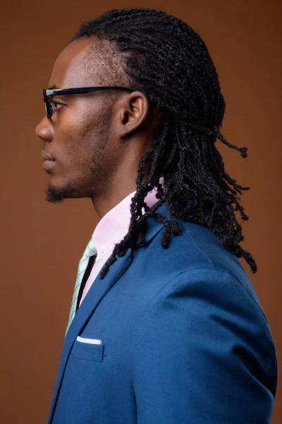 Junge gut aussehende afrikanische Geschäftsmann trägt Brille gegen br — Stockfoto