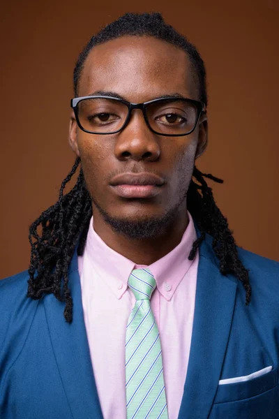 Jonge knappe Afrikaanse zakenman dragen van bril tegen br — Stockfoto