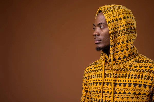 Jonge knappe man van de Afrikaanse tegen bruine achtergrond — Stockfoto
