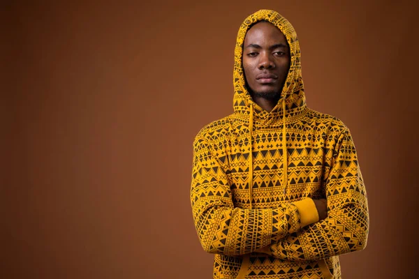 Joven hombre africano guapo sobre fondo marrón —  Fotos de Stock