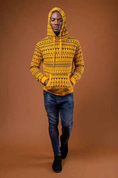 Junger gutaussehender afrikanischer Mann mit braunem Hintergrund — Stockfoto