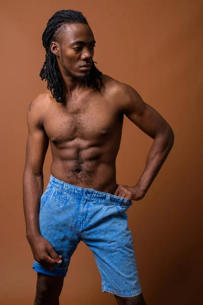 Fiatal csinos afrikai férfi félmeztelen, barna háttér — Stock Fotó