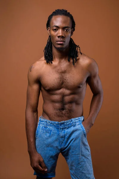 Fiatal csinos afrikai férfi félmeztelen, barna háttér — Stock Fotó