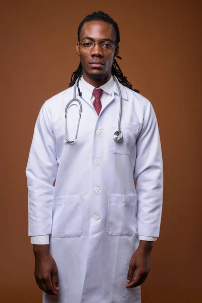 Jovem bonito Africano homem médico contra fundo marrom — Fotografia de Stock