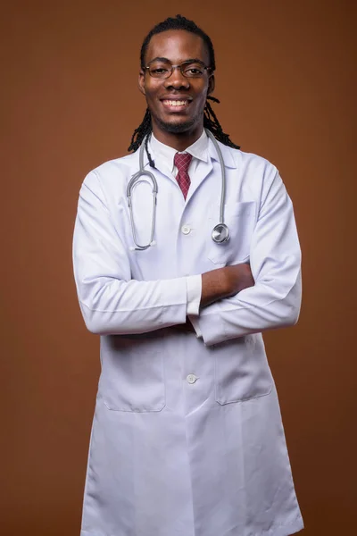 Jovem bonito Africano homem médico contra fundo marrom — Fotografia de Stock