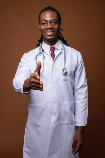 Jovem bonito Africano homem médico contra fundo marrom — Fotografia de Stock