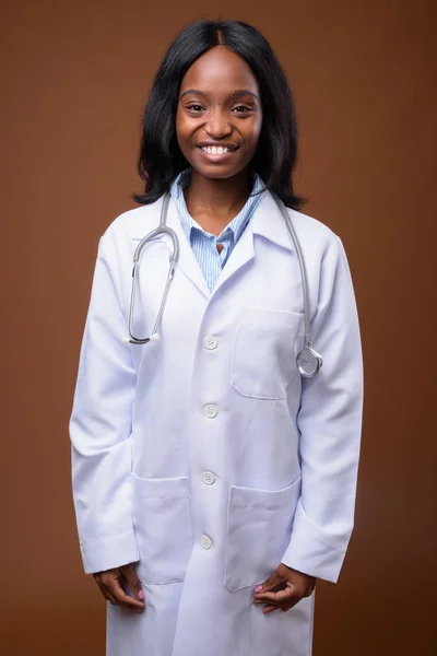 Junge schöne afrikanische Zulu-Ärztin gegen braunen Hintergrund — Stockfoto