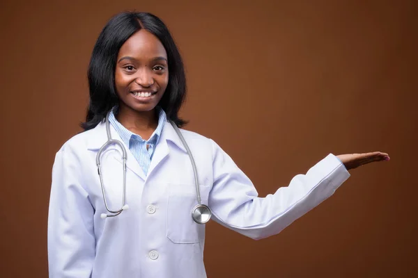 Junge schöne afrikanische Zulu-Ärztin gegen braunen Hintergrund — Stockfoto