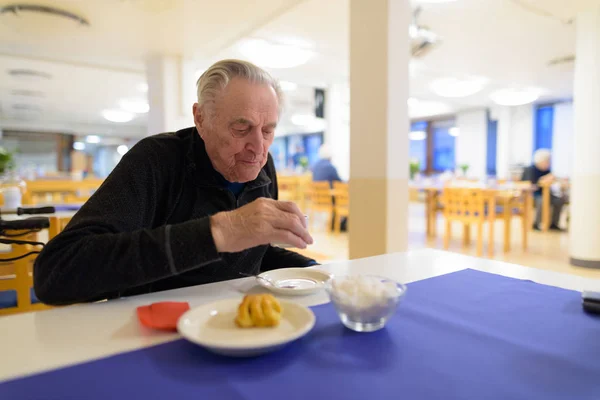 Senior man eten in de cafetaria in verpleeghuis — Stockfoto