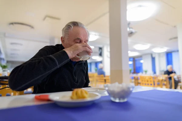 Senior man eten in de cafetaria in verpleeghuis — Stockfoto