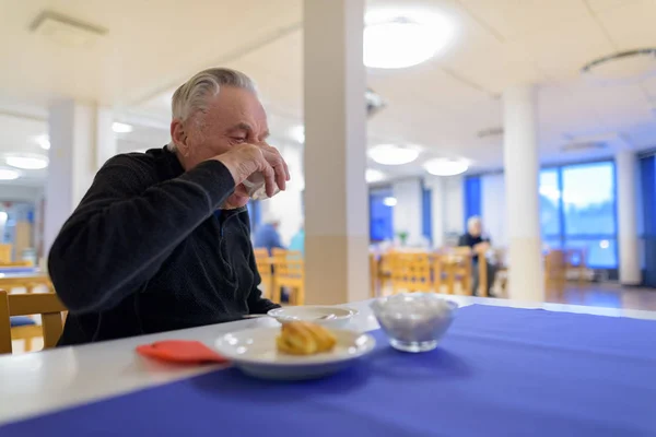 Senior man eten in de cafetaria in verpleeghuis — Stockfoto