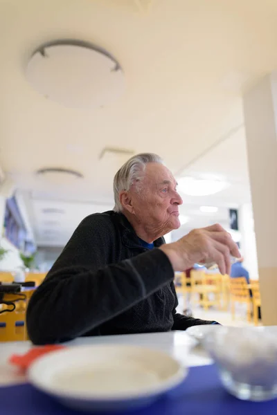 Senior man eating at the cafeteria in nursing home — Stock Photo, Image