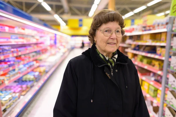 Vacker äldre kvinna shopping på mataffären — Stockfoto