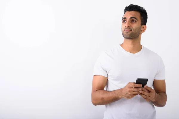 Jeune bel homme indien utilisant un téléphone portable contre le dos blanc — Photo