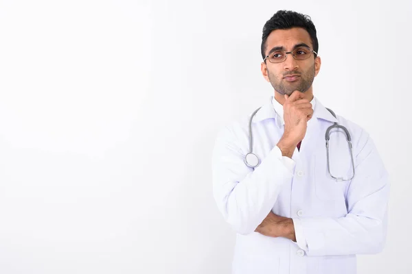 Young handsome Indian man doctor against white background — Stock Photo, Image