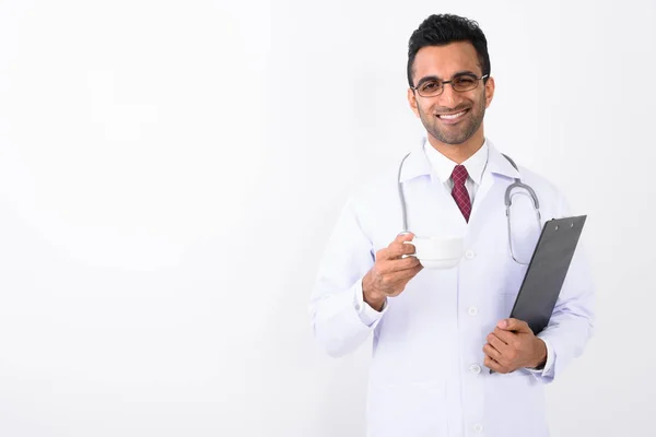 Young handsome Indian man doctor against white background — Stock Photo, Image