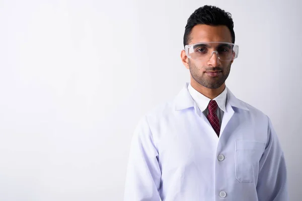 Young handsome Indian man doctor wearing protective glasses agai — Stock Photo, Image