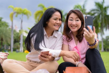 Bangkok, Tayland 'da parkta dinlenen iki olgun Asyalı kadının portresi.