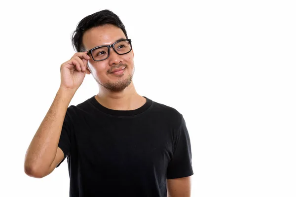 Studio ditembak pemuda Asia memegang kacamata sambil berpikir — Stok Foto