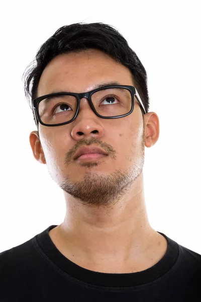 Face of young Asian man thinking while looking up and wearing ey — Stock Photo, Image