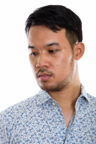 Cara de joven asiático hombre pensando mientras mira hacia abajo —  Fotos de Stock