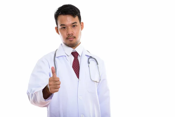 Studio shot of young Asian man doctor giving thumb up — Stock Photo, Image