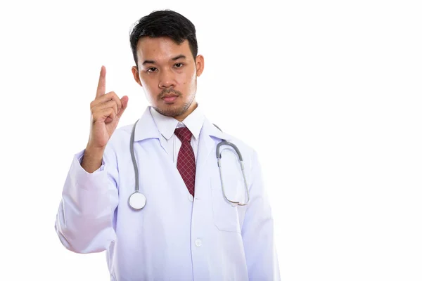 Estudio disparo de joven asiático hombre médico apuntando dedo hacia arriba — Foto de Stock