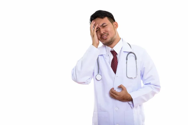 Studio skott av ung asiatisk man läkare ser stressad — Stockfoto