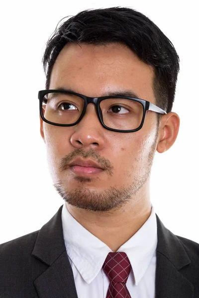 Gezicht van jonge Aziatische zakenman denken terwijl het dragen van eyeglasse — Stockfoto