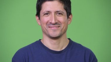 Yeşil arka planı gülümseyerek mutlu bir İspanyol adam