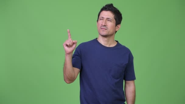 Hombre hispano pensando mientras señala con el dedo hacia arriba — Vídeo de stock