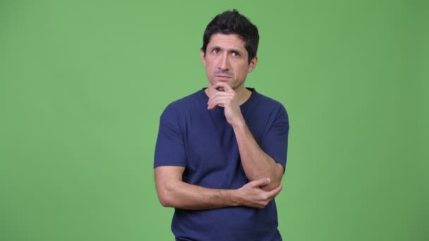 Hombre hispano pensando en fondo verde — Vídeo de stock